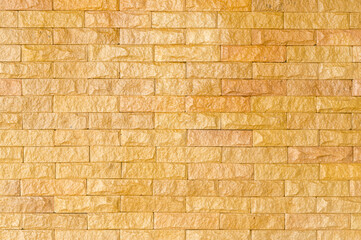 Shining golden brick wall background or texture, yellow stone used to decorate house or building
