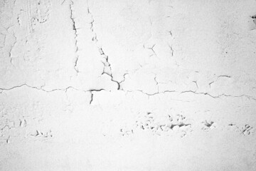 The white concrete wall is cracked, the paper is cracked