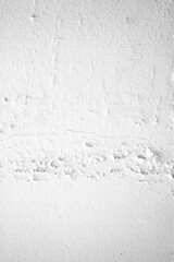 The white concrete wall is cracked, the paper is cracked
