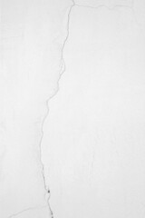 The white concrete wall is cracked, the paper is cracked