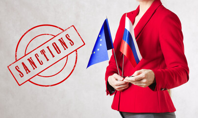 SANCTIONS.A young woman holds two flags of EU and Russia.