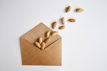 Almonds in a craft paper envelope on a light background. Healthy food. Healthy vegetarian natural...