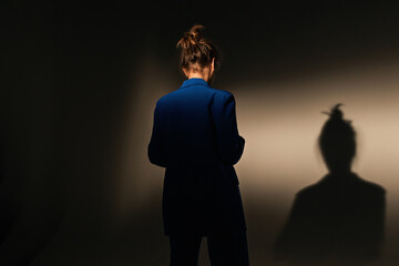 Fashion portrait of elegant trendy woman in red down jacket. Neon light, sunglasses, studio shot