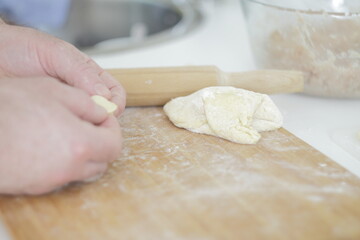 person kneading dough on the table