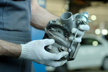 Repair and maintenance of the car. A new turbocharger is in the hands of an auto mechanic....