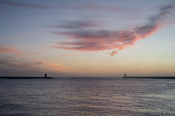 Beautiful sunset on the sea with two breakwaters in the background.