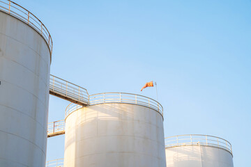 Petroleum oil storage tank with wind socks with blue sky. Industrial petroleum plant. Base oil for automotive engine oil and industrial oil application.