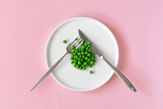 Top view of fresh green peas. Green peas  in white platel on pink background. Space to write text font