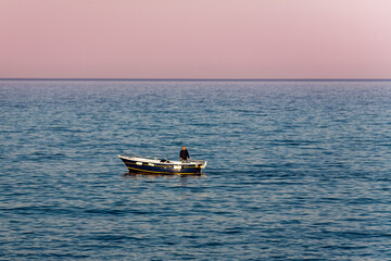 Motor boat and driver alone on a vast blue ocean
