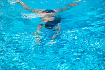 Fototapeta na wymiar woman swimming under blue water. summer vacation. underwater