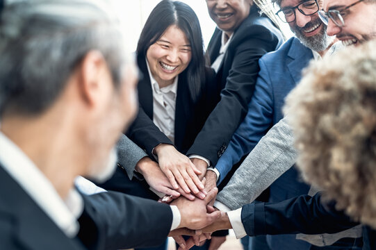 Multiracial business people stacking hands together in office - Teamwork concept