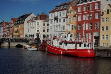 Fototapeta premium red small boat on the Neuhafn canal against the background of houses