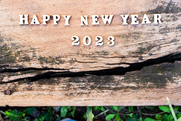 Happy New Year 2023 concept. Wood text on old wooden plank. Empty space.