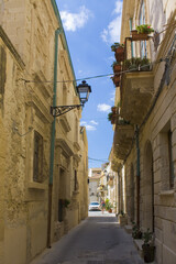Fototapeta na wymiar Narrow and picturesque street on Ortigia Island in Siracusa, Sicily, Italy 