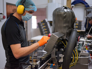 Profile of a man working with an electronic beer canning machine