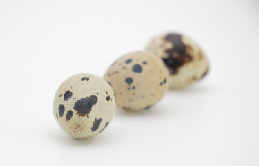 Fototapeta premium Three quail eggs isolated on white background, organic food ingredients Can be used for cooking.