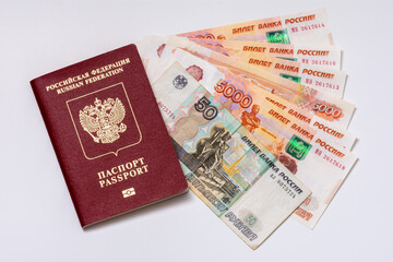 Passeport de la Fédération de Russie et billets de banque russes (roubles) sur fond blanc. Concepts de voyage, de sanctions économiques, de transferts d'argent  et d'inflation pour les citoyens russes