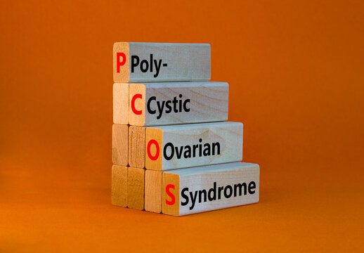 PCOS poly-cystic ovarian syndrome symbol. Concept words PCOS poly-cystic ovarian syndrome on blocks on a beautiful orange background. Medical PCOS poly-cystic ovarian syndrome concept.