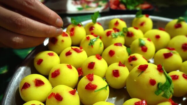 closeup decorating several yellow potato lime causa balls with bell pepper on a bowl for christmas dinner in 4k