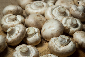 Champignons on a wooden background. Fresh white mushrooms. A lot of mushrooms