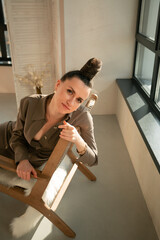 Ukrainian brunette girl sitting in a wooden chair portrait

Young brown-haired woman beautiful hands slender legs reception beige interior fashionable dress has wall hairstyle beautiful leather 