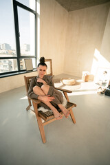 Ukrainian brunette girl sitting in a wooden chair portrait

Young brown-haired woman beautiful hands slender legs reception beige interior fashionable dress has wall hairstyle beautiful leather 