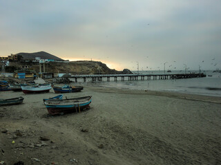 Artisanal fishing boats stranded on the coast of a beach in Callao - Peru.