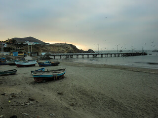 Fototapeta premium Artisanal fishing boats stranded on the coast of a beach in Callao - Peru.