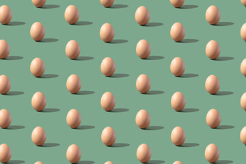 Pattern made of eggs on pastel green background. Minimal food concept.
