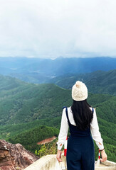 Fototapeta na wymiar A girl enjoying a breathtaking view from mountain top in Binh Lieu, Vietnam