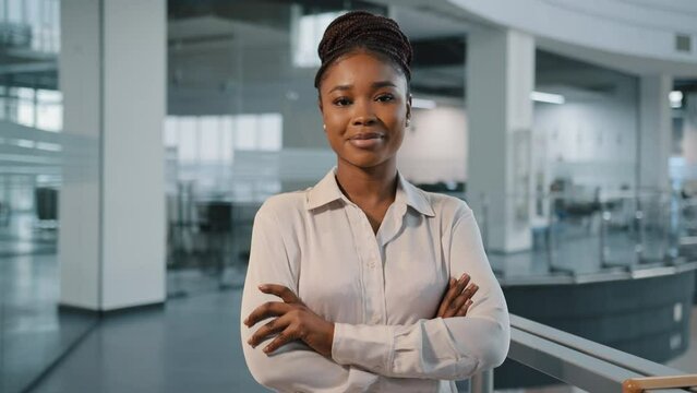 African millennial 30s successful confident strong businesswoman feminism worker lady boss female leader multiracial woman in formal shirt posing crossing arms looking at camera in office corporate