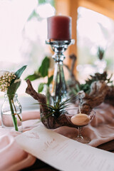Tischdekoration zur Hochzeit mit Kerzenständer und Wurzeln aus Holz und Menükarte