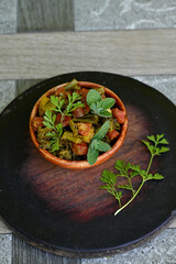 closeup the fried peas,brooklyn ,red carrot, with mint and coriander leaves vegetable made i the wooden bowl over out of focus wooden brown background.
