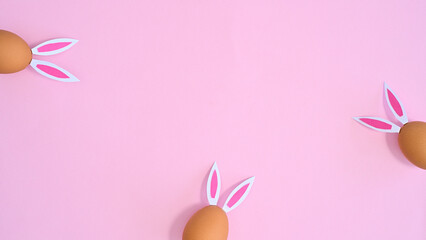 Creative copy space backround with natural eggs with rabbit ears on pastel pink theme. Flat lay Easter concept