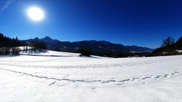 A panoramic hiking trail with scenic view on Mittagskogel (Kepa) and a snow covered alpine meadow in the Karawanks Alps in Carinthia, Austria, Europe. Winter wonderland near Lake Faak. Ski touring
