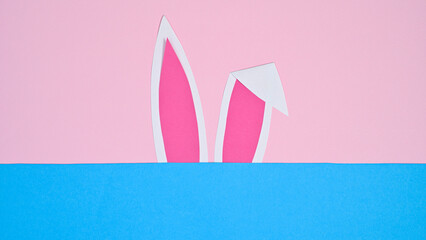 Bunny ears on pastel pink and blue background. FLat lay minimal creative concept