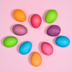 Creative arrangement with colorful vibrant natural eggs on pastel pink background. Flat lay Easter concept