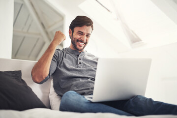 Yes its finally downloaded. Shot of a handsome young man surfing the net at home.