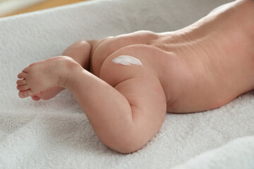 Obraz na płótnie Canvas Cute little baby with cream on body, closeup