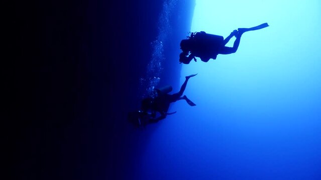 cave diving underwater scuba divers exploring caves and having fun ocean scenery sun beams and rays background
