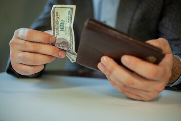 man's hand with 100 US dollars