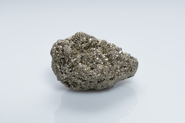 Raw crystalline pyrite (iron pyrite, fool's gold). Mineral pyrite from the group of sulfides. The mineral pyrite on a white background