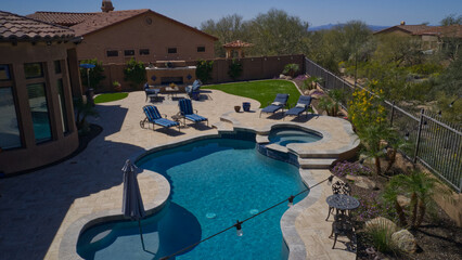 Travertine deck with pool, spa and outdoor kitchen.