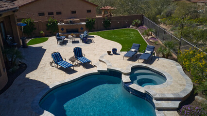Travertine deck with pool, spa and outdoor kitchen.
