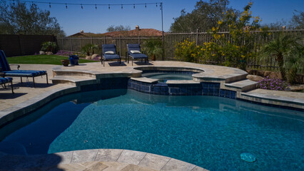 Travertine deck with pool, spa and outdoor kitchen.