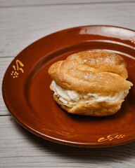 Dulce de profiterol con nata sobre madera