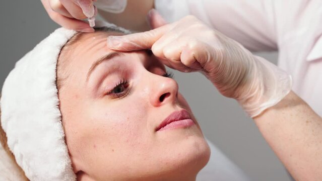Injection at spa salon. Doctor hands in gloves. Closeup. Pretty female patient. Beauty treatment. Healthy skin procedure. Young women face. Plasmolifting rejuvenation