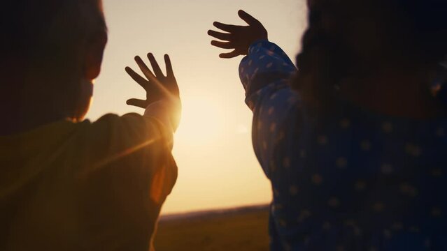 happy family kids people group pull hands to the sun teamwork. silhouette people party dancing recreation holiday. kids at a music lifestyle concert pull their hands up. religion concept sunlight
