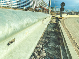construction of a new area of the city. the road is fenced with protective elements, the...