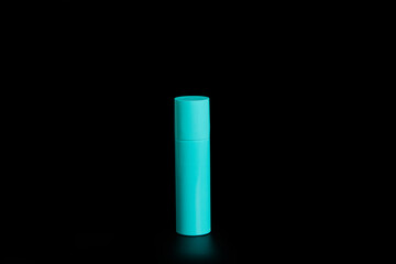 Light blue spray can on black background with reflection below.